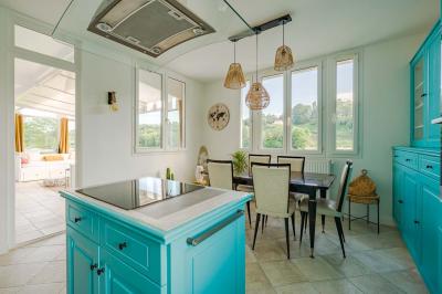 Tables et chaises en bois disposées en extérieur près d'une rivière, avec parasols et végétation en arrière-plan.