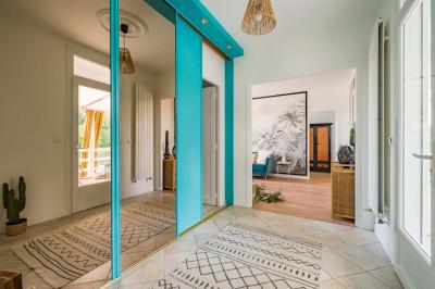 Tables et chaises en bois disposées en extérieur près d'une rivière, avec parasols et végétation en arrière-plan.