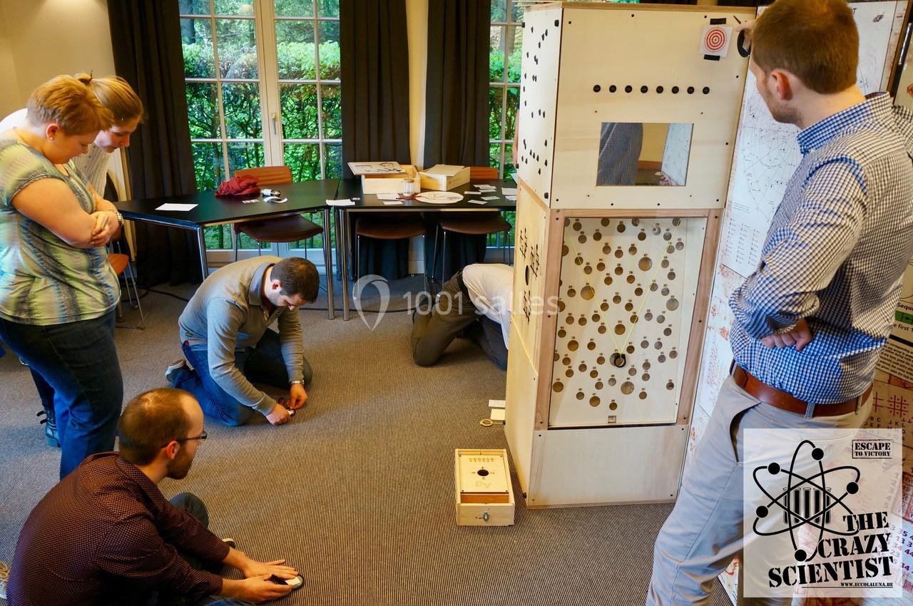 Des personnes participent à une activité collaborative autour d'une grande structure en bois dans une salle lumineuse.