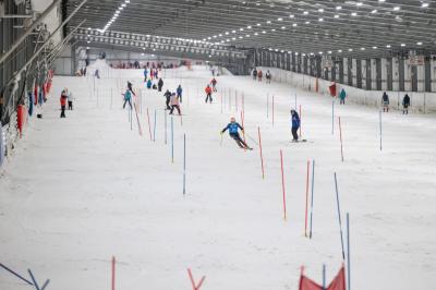 Salle de réception décorée avec des guirlandes lumineuses, tables dressées et éclairage tamisé bleu et rose.