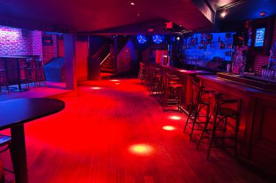 Un homme souriant avec des lunettes de soleil pose avec une femme dans un environnement festif et animé.