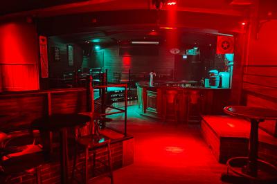 Un homme souriant avec des lunettes de soleil pose avec une femme dans un environnement festif et animé.