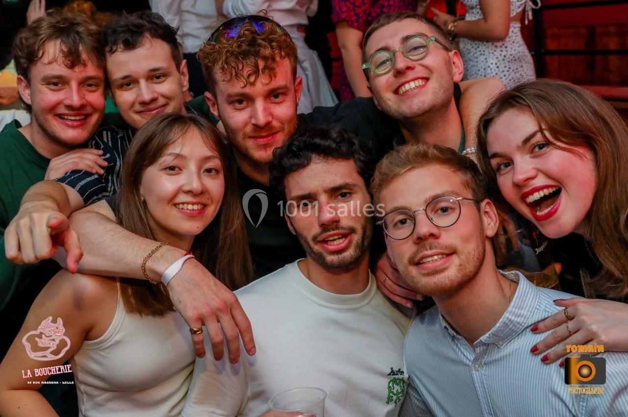 Un groupe de jeunes adultes souriants posant ensemble dans un cadre festif.