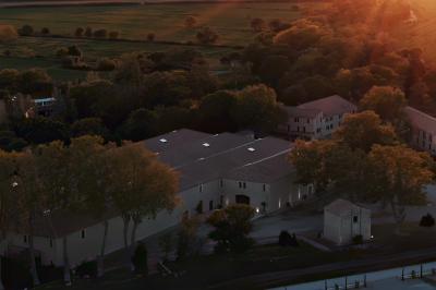 Paysage au coucher du soleil avec des champs, une clôture en bois et des montagnes à l'horizon sous un ciel partiellement…