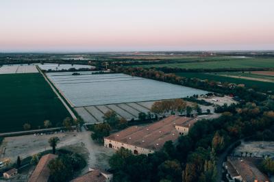 Paysage au coucher du soleil avec des champs, une clôture en bois et des montagnes à l'horizon sous un ciel partiellement…