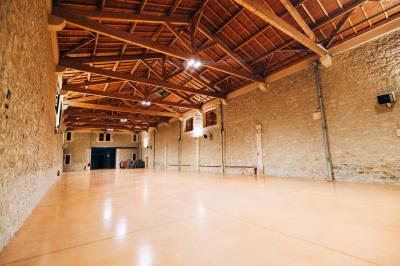 Paysage au coucher du soleil avec des champs, une clôture en bois et des montagnes à l'horizon sous un ciel partiellement…