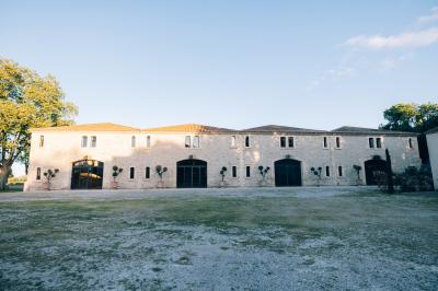 Paysage au coucher du soleil avec des champs, une clôture en bois et des montagnes à l'horizon sous un ciel partiellement…