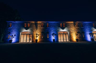 Paysage au coucher du soleil avec des champs, une clôture en bois et des montagnes à l'horizon sous un ciel partiellement…