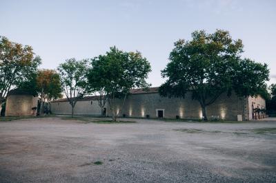 Paysage au coucher du soleil avec des champs, une clôture en bois et des montagnes à l'horizon sous un ciel partiellement…