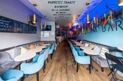 Terrasse vide de cafés et restaurants sur une rue pavée bordée de bâtiments en briques et en pierre.