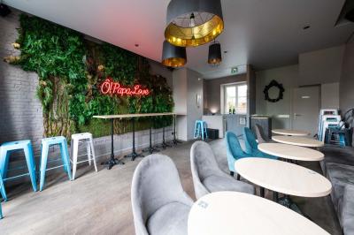 Terrasse vide de cafés et restaurants sur une rue pavée bordée de bâtiments en briques et en pierre.