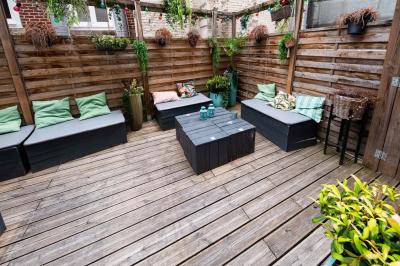 Terrasse vide de cafés et restaurants sur une rue pavée bordée de bâtiments en briques et en pierre.