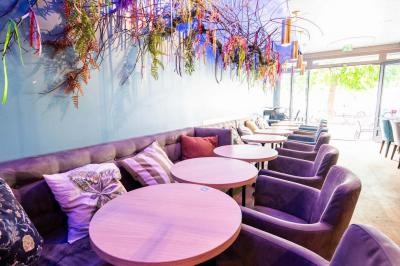 Terrasse vide de cafés et restaurants sur une rue pavée bordée de bâtiments en briques et en pierre.