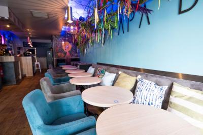 Terrasse vide de cafés et restaurants sur une rue pavée bordée de bâtiments en briques et en pierre.