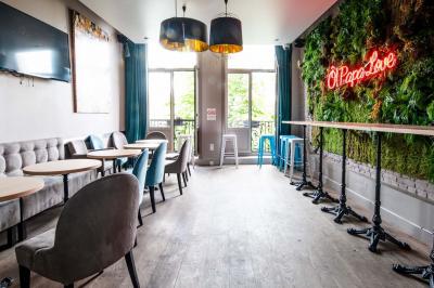 Terrasse vide de cafés et restaurants sur une rue pavée bordée de bâtiments en briques et en pierre.