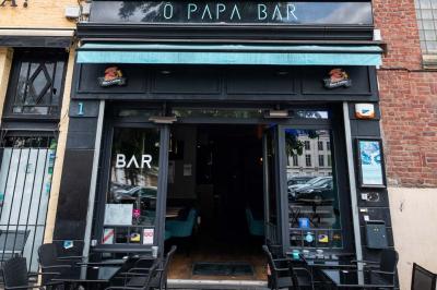 Terrasse vide de cafés et restaurants sur une rue pavée bordée de bâtiments en briques et en pierre.