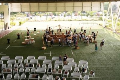 Table ronde en bois entourée de chaises à motifs rouges et blancs, située dans un jardin avec des plantes et des fleurs.