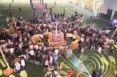 Table ronde en bois entourée de chaises à motifs rouges et blancs, située dans un jardin avec des plantes et des fleurs.