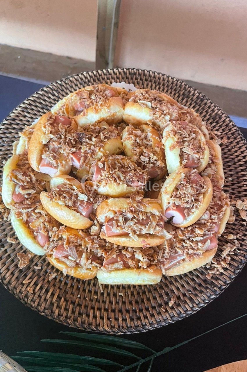 Location salle Cuers (Var) - L'atrium #23 Plateau de petits pains garnis de jambon et d'oignons frits, disposés en cercle sur un panier en osier.