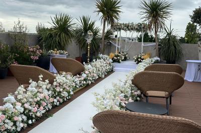 Salon mansardé avec canapé gris, fauteuils, tables d'appoint et éclairage naturel provenant d'une fenêtre inclinée.