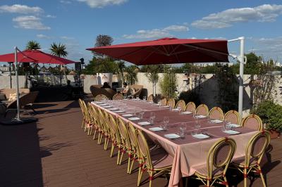 Salon mansardé avec canapé gris, fauteuils, tables d'appoint et éclairage naturel provenant d'une fenêtre inclinée.