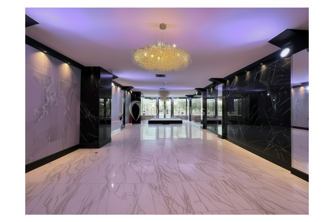 Salle moderne avec sol en marbre blanc, murs noirs brillants et grand lustre central illuminant l'espace.