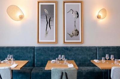 Salle de conférence avec rangées de chaises colorées, un pupitre à l'avant et des panneaux en bois en arrière-plan.