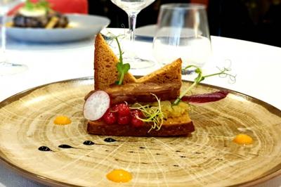 Salle de conférence avec rangées de chaises colorées, un pupitre à l'avant et des panneaux en bois en arrière-plan.