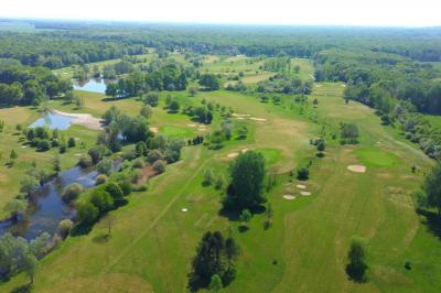Salle de conférence avec rangées de chaises colorées, un pupitre à l'avant et des panneaux en bois en arrière-plan.