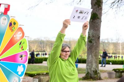 Salle de conférence avec rangées de chaises colorées, un pupitre à l'avant et des panneaux en bois en arrière-plan.