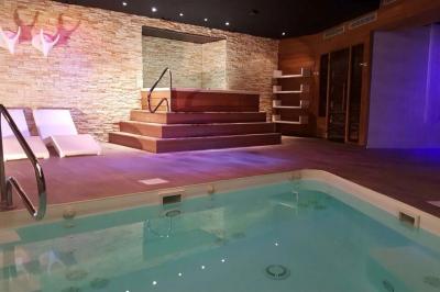 Salle de conférence avec rangées de chaises colorées, un pupitre à l'avant et des panneaux en bois en arrière-plan.