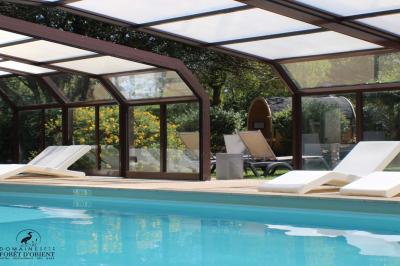 Salle de conférence avec rangées de chaises colorées, un pupitre à l'avant et des panneaux en bois en arrière-plan.