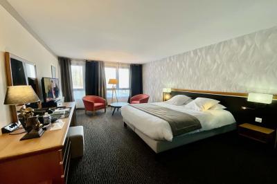 Salle de conférence avec rangées de chaises colorées, un pupitre à l'avant et des panneaux en bois en arrière-plan.