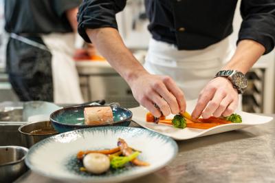 Salle de conférence avec rangées de chaises colorées, un pupitre à l'avant et des panneaux en bois en arrière-plan.