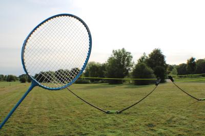 Salle de conférence avec rangées de chaises colorées, un pupitre à l'avant et des panneaux en bois en arrière-plan.