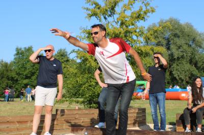 Salle de conférence avec rangées de chaises colorées, un pupitre à l'avant et des panneaux en bois en arrière-plan.