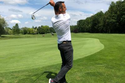 Salle de conférence avec rangées de chaises colorées, un pupitre à l'avant et des panneaux en bois en arrière-plan.