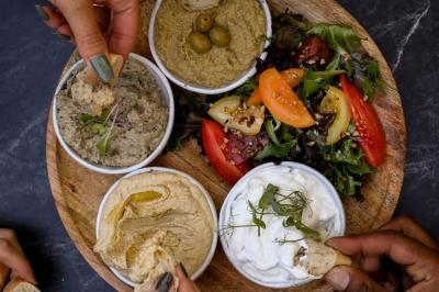 Table garnie de desserts variés, incluant une pièce montée, des verrines et des pâtisseries, dans un cadre tamisé.