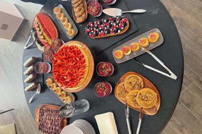 Table garnie de desserts variés, incluant une pièce montée, des verrines et des pâtisseries, dans un cadre tamisé.