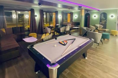 Table garnie de desserts variés, incluant une pièce montée, des verrines et des pâtisseries, dans un cadre tamisé.