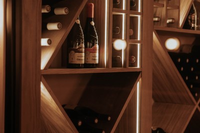 Terrasse extérieure avec tables et chaises noires, entourée de végétation et de bâtiments résidentiels.