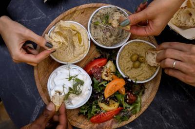 Table garnie de desserts variés, incluant une pièce montée, des verrines et des pâtisseries, dans un cadre tamisé.