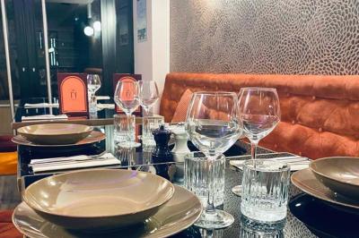 Table garnie de desserts variés, incluant une pièce montée, des verrines et des pâtisseries, dans un cadre tamisé.