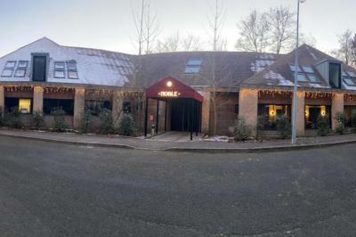 Table garnie de desserts variés, incluant une pièce montée, des verrines et des pâtisseries, dans un cadre tamisé.