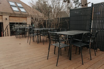 Salle de restaurant chaleureuse avec banquettes en velours rouge, chaises en bois et éclairage tamisé.