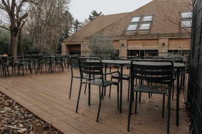 Salle de restaurant chaleureuse avec banquettes en velours rouge, chaises en bois et éclairage tamisé.