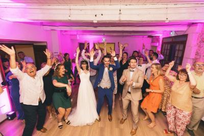 Cour intérieure pavée entourée de murs en pierre, avec des plantes grimpantes et des fenêtres sur une façade.