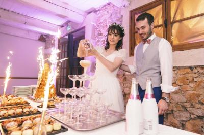 Cour intérieure pavée entourée de murs en pierre, avec des plantes grimpantes et des fenêtres sur une façade.