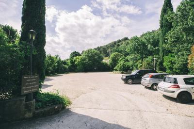 Cour intérieure pavée entourée de murs en pierre, avec des plantes grimpantes et des fenêtres sur une façade.