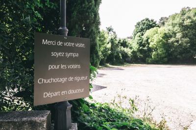 Cour intérieure pavée entourée de murs en pierre, avec des plantes grimpantes et des fenêtres sur une façade.